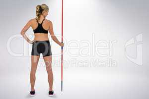 Composite image of athlete standing with javelin