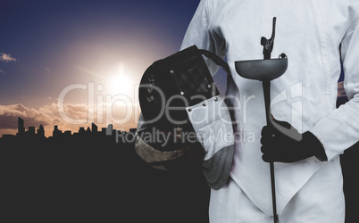 Composite image of mid-section of man standing with fencing mask