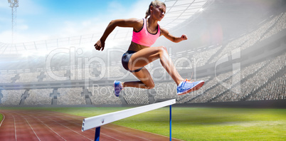 Composite image of sporty woman jumping a hurdle