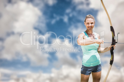 Composite image of portrait of happy sportswoman posing with a b