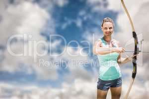 Composite image of portrait of happy sportswoman posing with a b