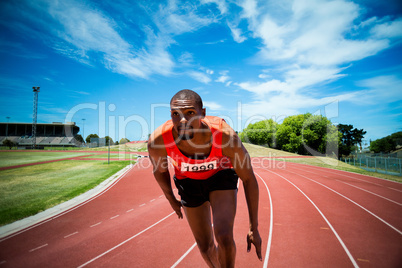 Composite image of handsome man preparing to start running