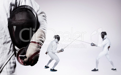 Composite image of mid-section of man standing with fencing mask