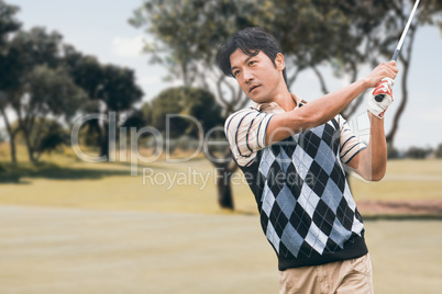 Man playing golf against nature scene