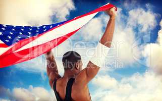 Composite image of athlete holding american flag