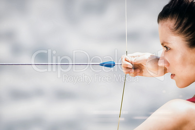Composite image of close up of sportswoman practising archery on