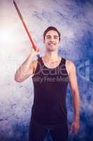 Composite image of happy male athlete holding javelin