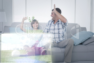 Composite image of father and son giving high-five in front of s