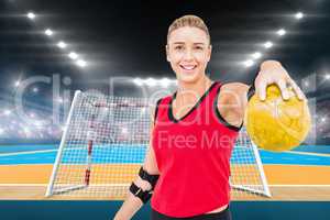 Composite image of female athlete with elbow pad holding handbal