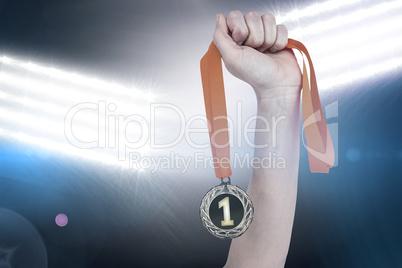 Composite image of athlete holding gold medal after victory