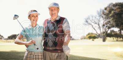 Composite image of couple golf players looking the camera