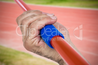 Composite image of close-up of hand holding javelin