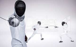 Composite image of man wearing fencing suit practicing with swor