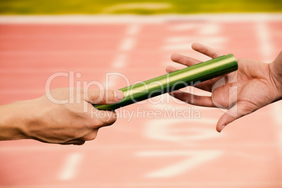 Composite image of  man passing the baton to partner on track