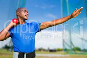 Composite image of front view of sportsman practising shot put