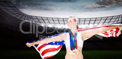 Composite image of portrait of happy sportswoman with medals hol