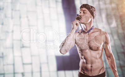 Composite image of swimmer kissing his gold medal