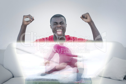 Composite image of happy man is watching sport on television