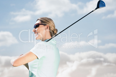 Smiling woman playing golf