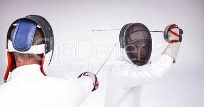 Composite image of man wearing fencing suit practicing with swor