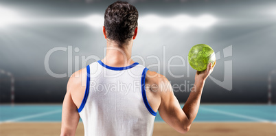 Composite image of rear view of male athlete holding ball