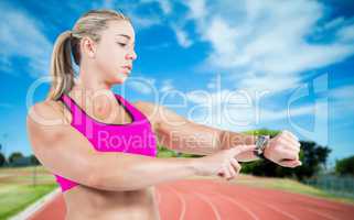 Composite image of female athlete using her smart watch