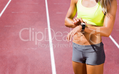 Composite image of sporty woman looking her watch