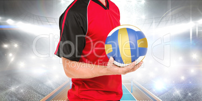 Composite image of sportsman holding a volleyball