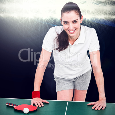 Composite image of female athlete leaning on ping pong table