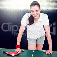 Composite image of female athlete leaning on ping pong table