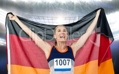 Composite image of athlete posing with german flag after victory