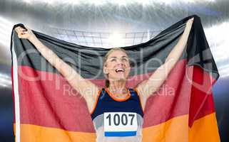 Composite image of athlete posing with german flag after victory