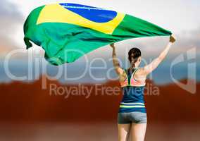 Composite image of rear view of sportswoman raising a brazilian