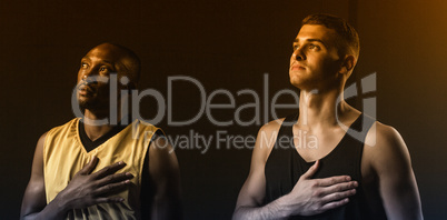 Portrait of basketball players looking up and putting hand on he