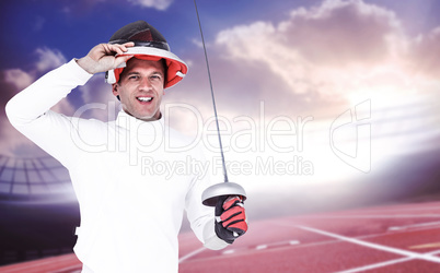 Composite image of man wearing fencing suit practicing with swor