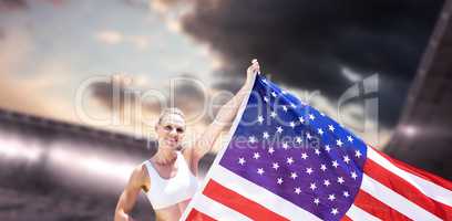 Composite image of happy sportswoman holding an american flag