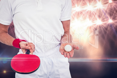 Composite image of male athlete holding ping pong ball and paddl