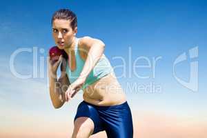 Composite image of sportswoman practising the shot put