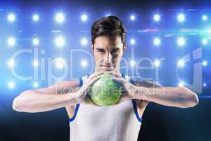 Composite image of portrait of happy athlete man holding ball