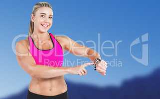 Composite image of female athlete using her smart watch