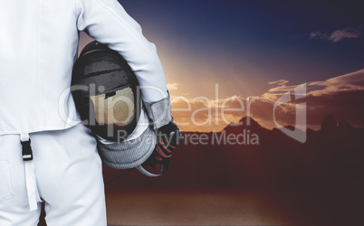 Composite image of rear view of swordsman holding fencing mask a