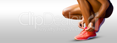 Composite image of close up of sportswoman is lacing shoes