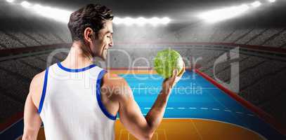 Composite image of happy athlete male holding a ball