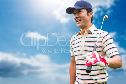 Man holding a golf club against blue sky