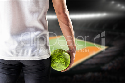 Composite image of mid section of athlete man holding ball