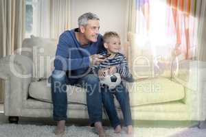 Composite image of father and son are watching sport match on te