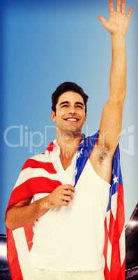 Athlete with american flag wrapped around his body against compo