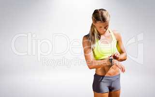 Composite image of sporty woman looking her watch