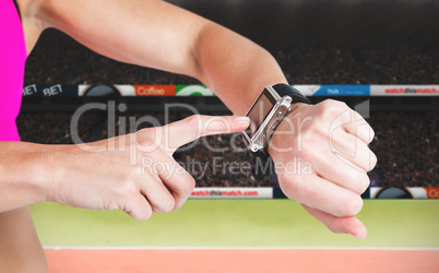 Composite image of female athlete using her smart watch