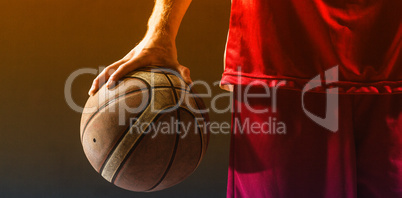 Close up on a basketball held by basketball player